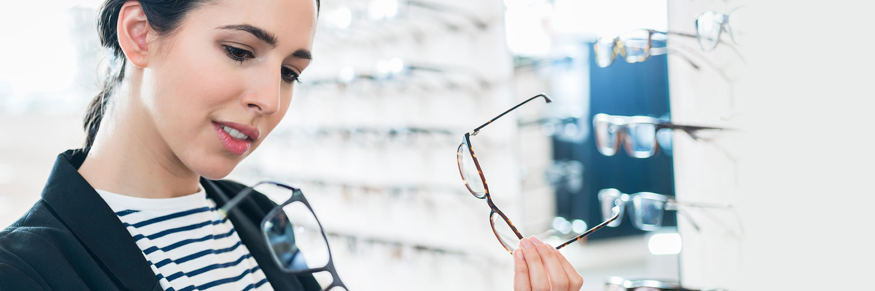 woman looking at different eyeglasses 